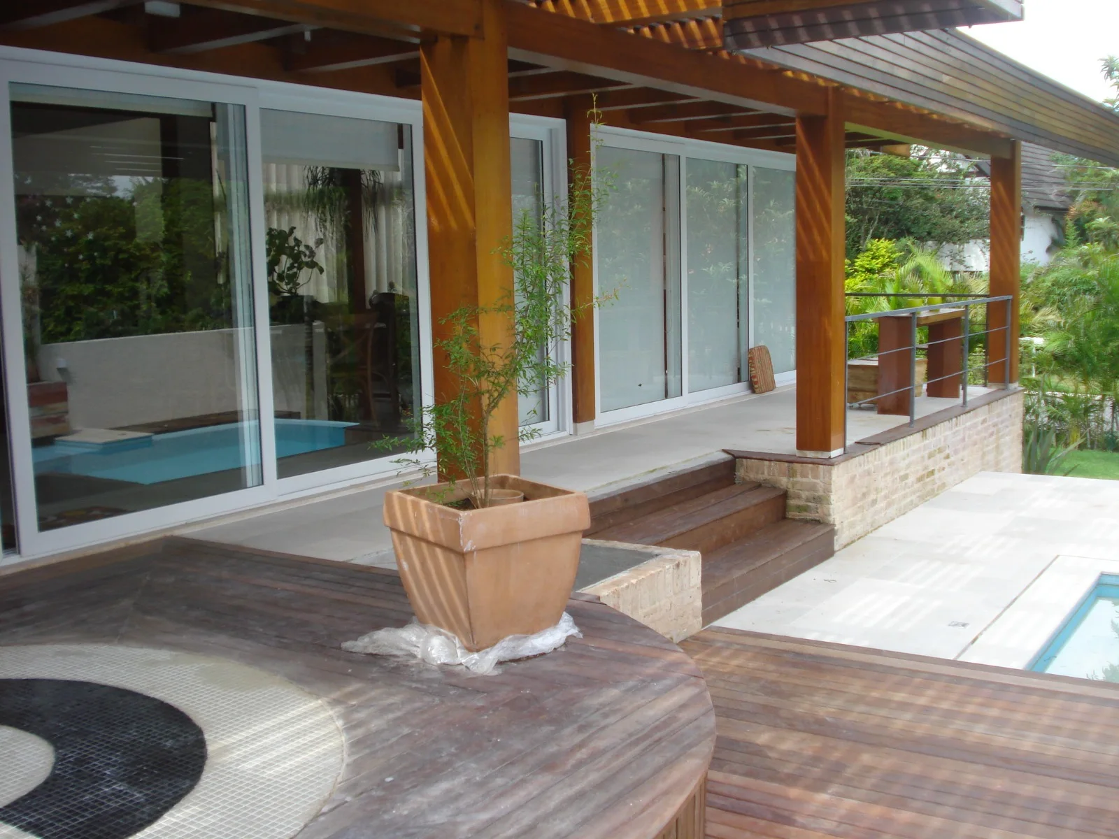 Deck de madeira de uma residência integrado à piscina e ao jardim