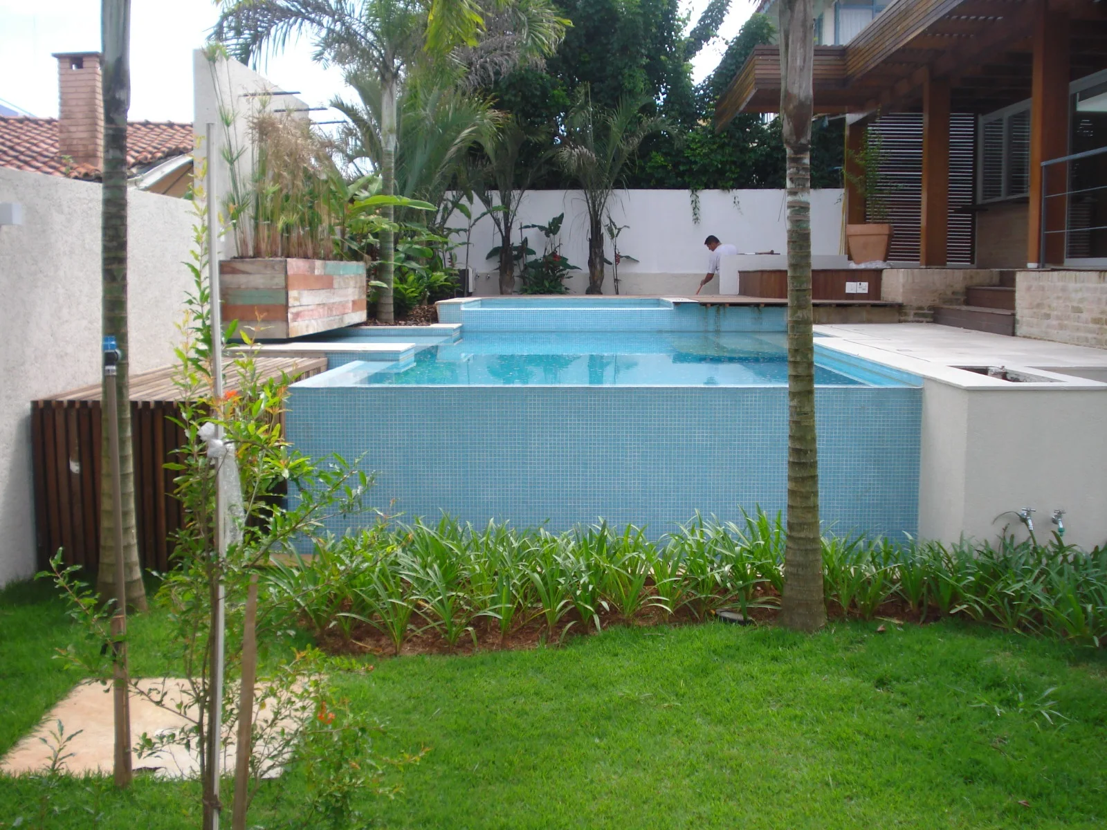 Piscina cercada pelo jardim da residência